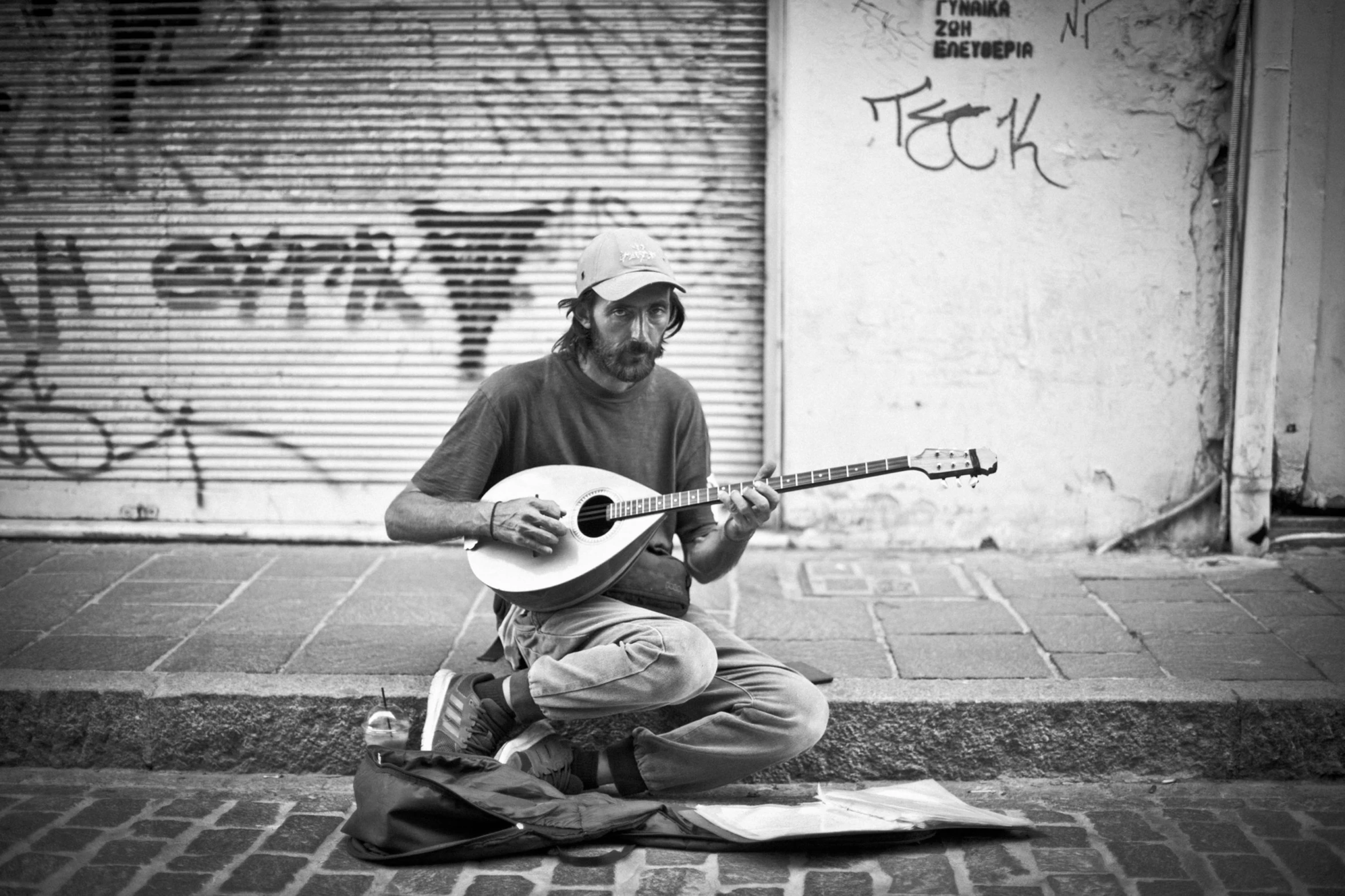 a person is playing a small guitar on a city street
