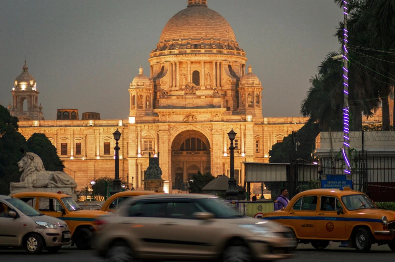 taxi cabs at night in front of an ornate building