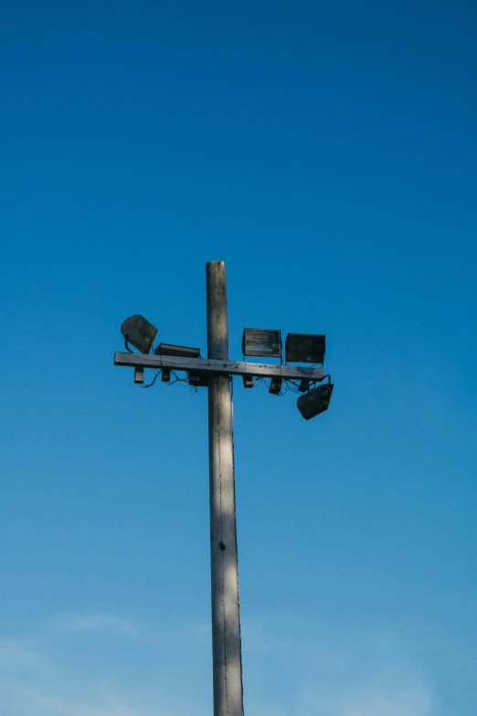 a bird is sitting in the sky beside an electrical pole