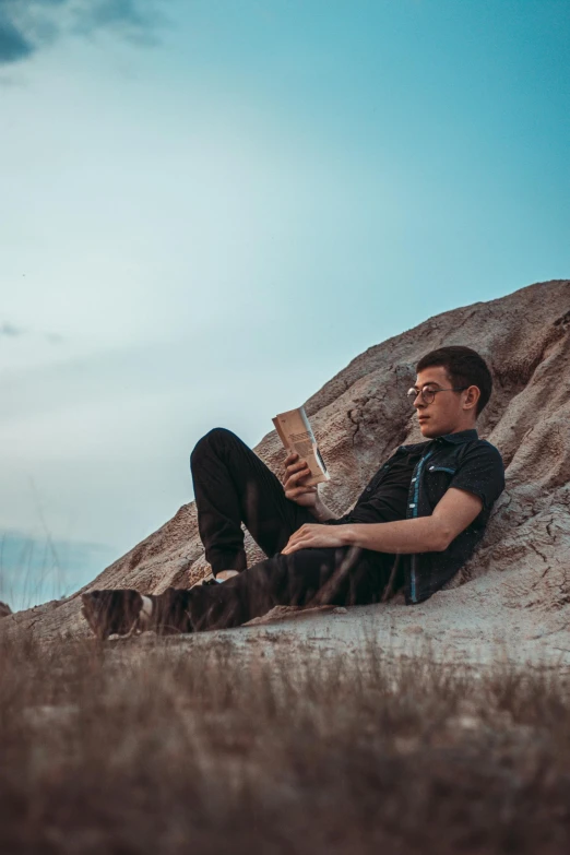 a man sitting on top of a stone covered ground