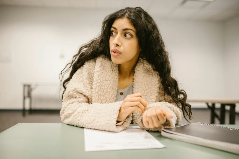 the girl is taking notes at the table