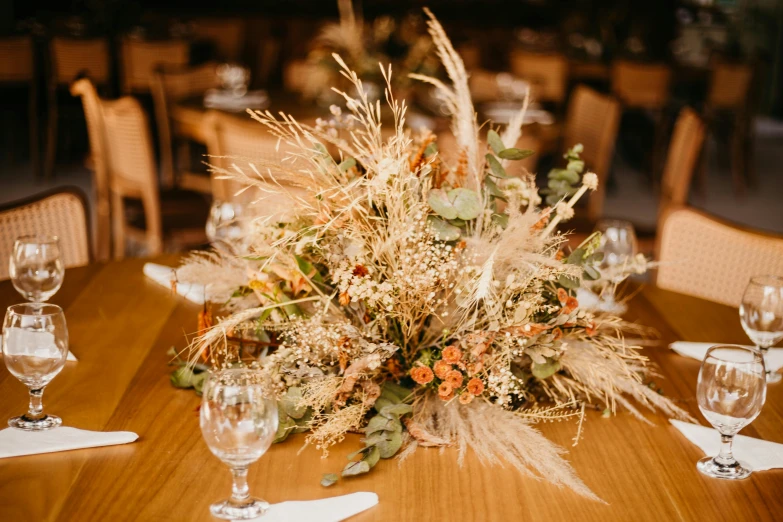 table centerpiece with tall dried wheat flowers on it