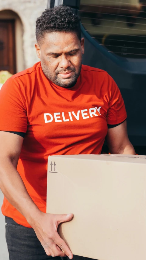 a man in red shirt holding a box