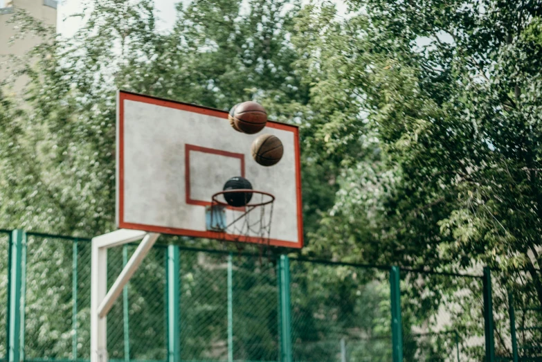 two basketballs are being tossed at a basketball hoop