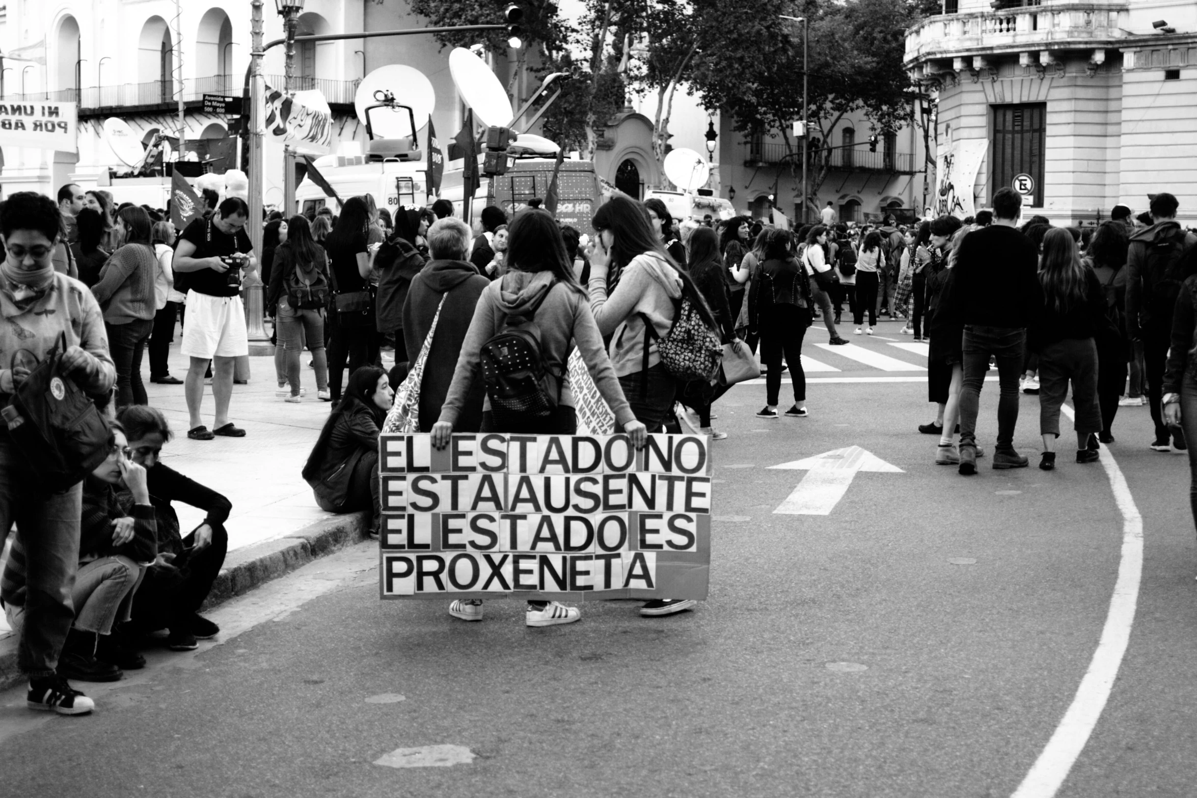 a man holding a sign while standing in the middle of a street