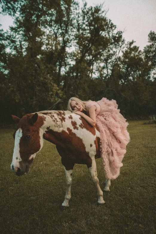 a horse that has a pink tail standing in the grass