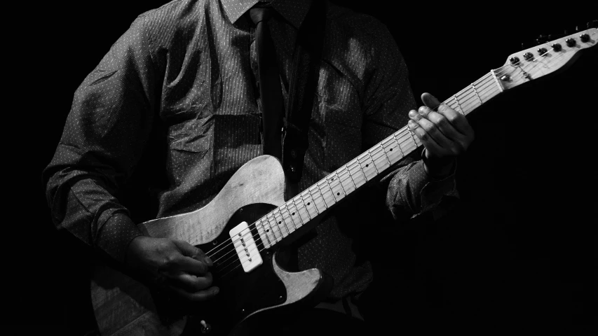 a person playing a guitar in black and white