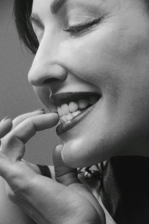 a woman holding her hand up to her mouth while she brushes her teeth