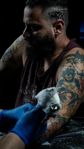 tattooed male worker working with a blow gun