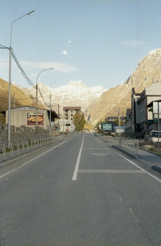 an empty street with mountains in the background