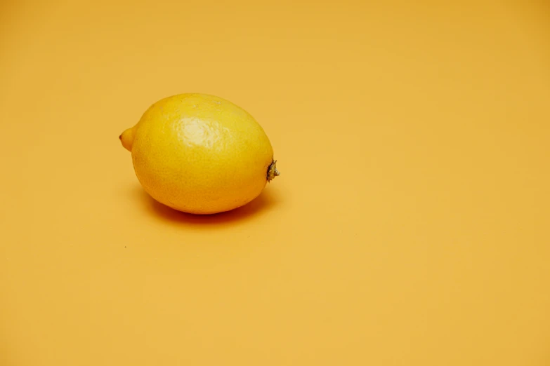 an orange is laying down on a yellow background