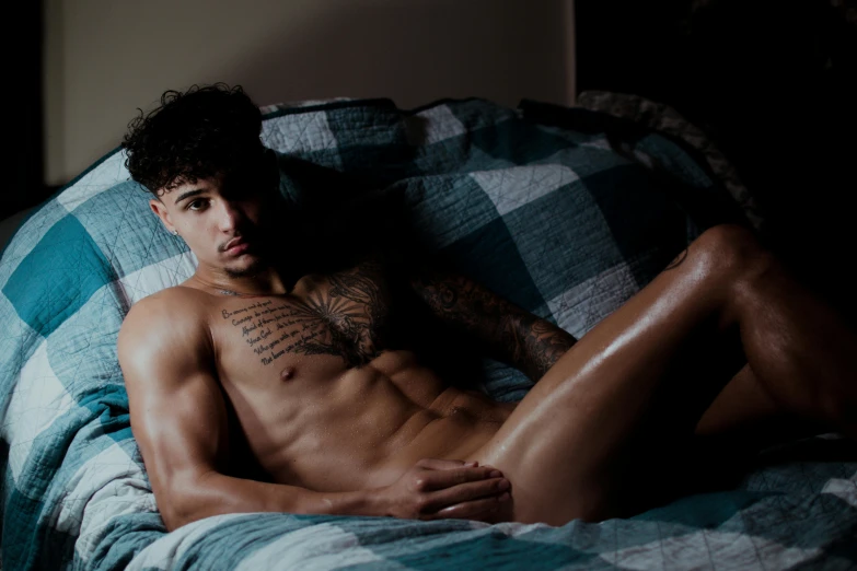 a shirtless man laying in bed in his underwear