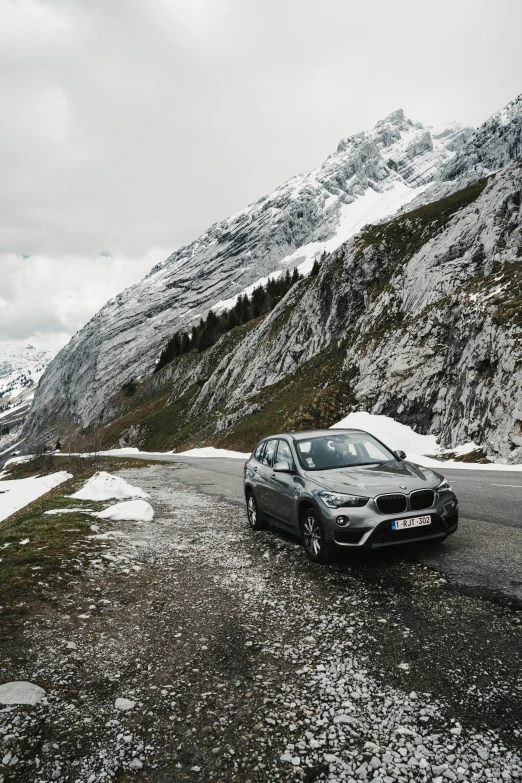 the car is parked near the snow covered mountain