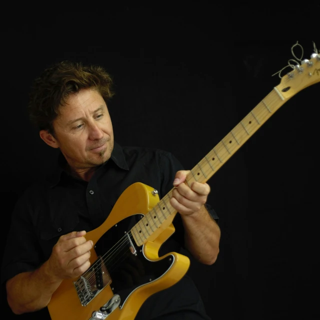 a man is playing an electric guitar with his hands