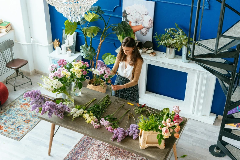 the woman is arranging flowers and looking at it