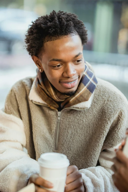 a young man smiling while looking at his cell phone