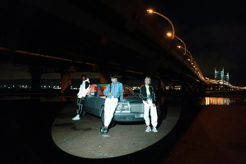 two people dressed in white stand next to a car