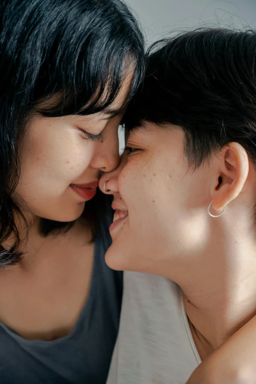 two beautiful young women kissing each other on a bed