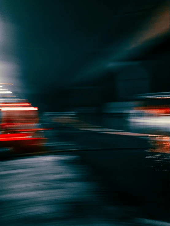 a car passing by a red building in the dark