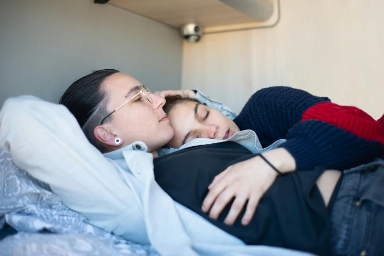 a man and a woman lying on top of a bed