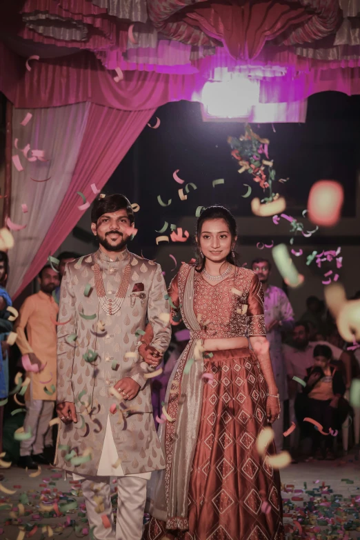 two people standing next to each other under confetti