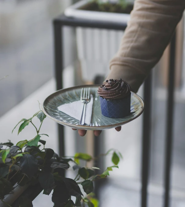 someone holding a plate with a cake and fork