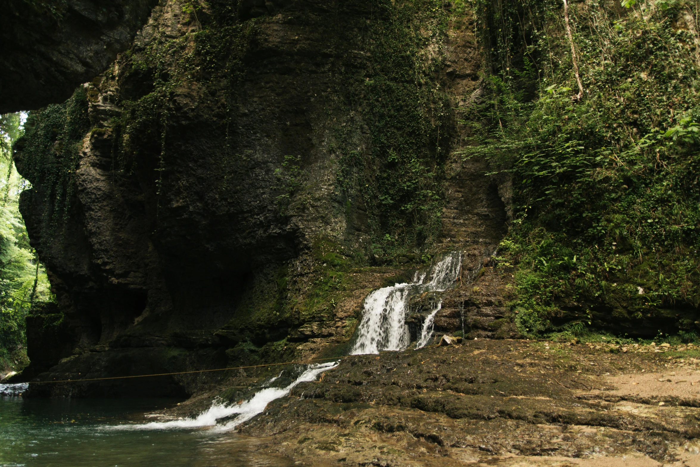 waterfall coming out of the deep side of a jungle