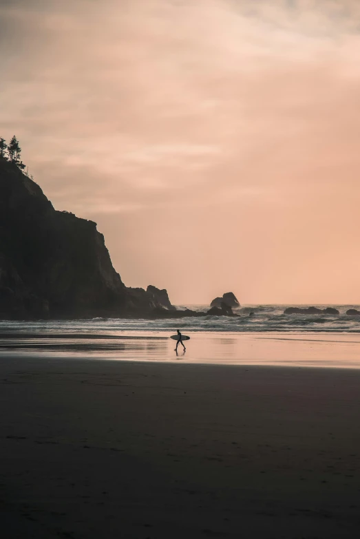 two people are standing on a beach with a surfboard