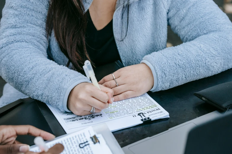 a young lady is taking notes from her notebook