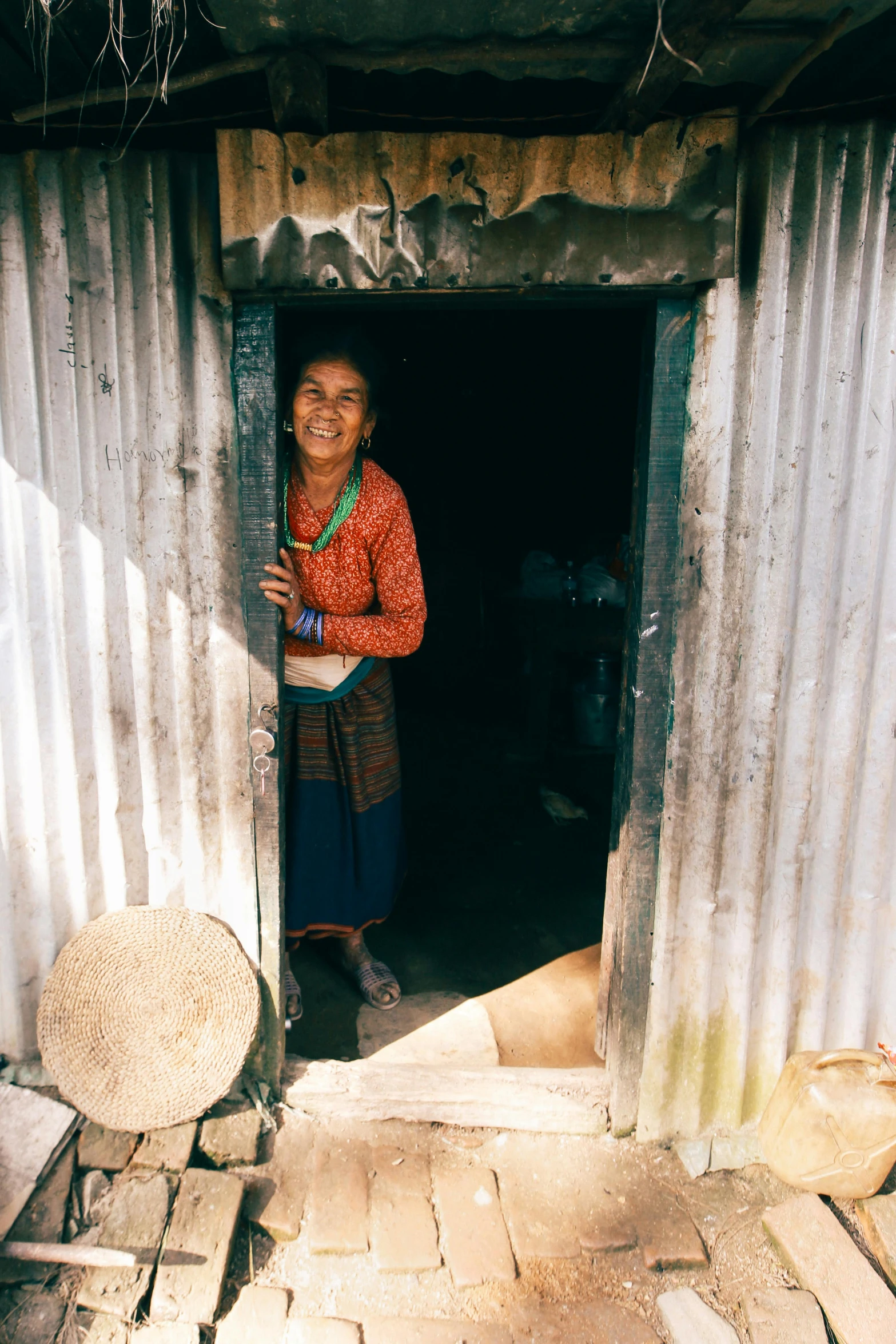 an indian woman stands in the entrance to her house