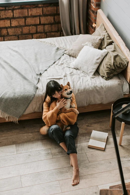 a woman sitting on the floor holding a dog