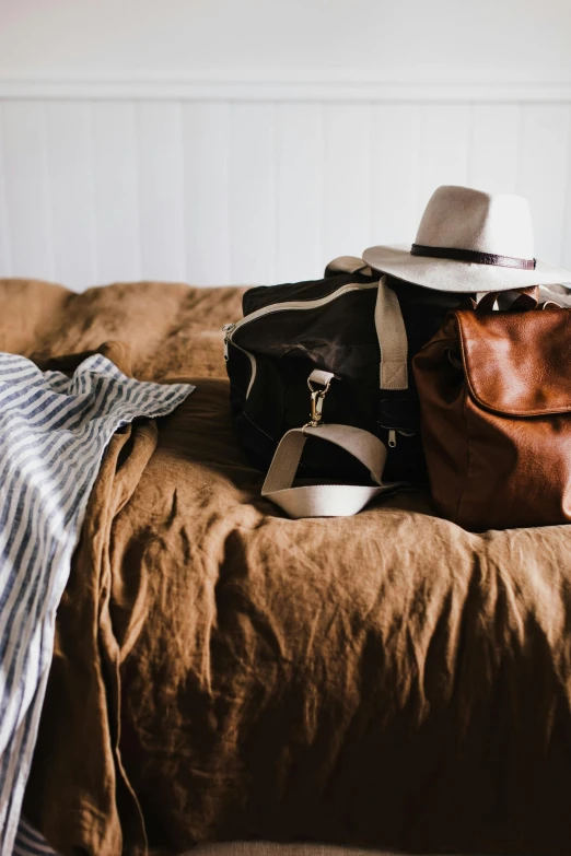 a brown bag is on top of a tan bed