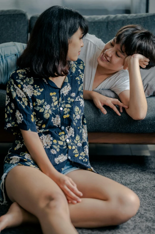 two women sitting on the floor and talking