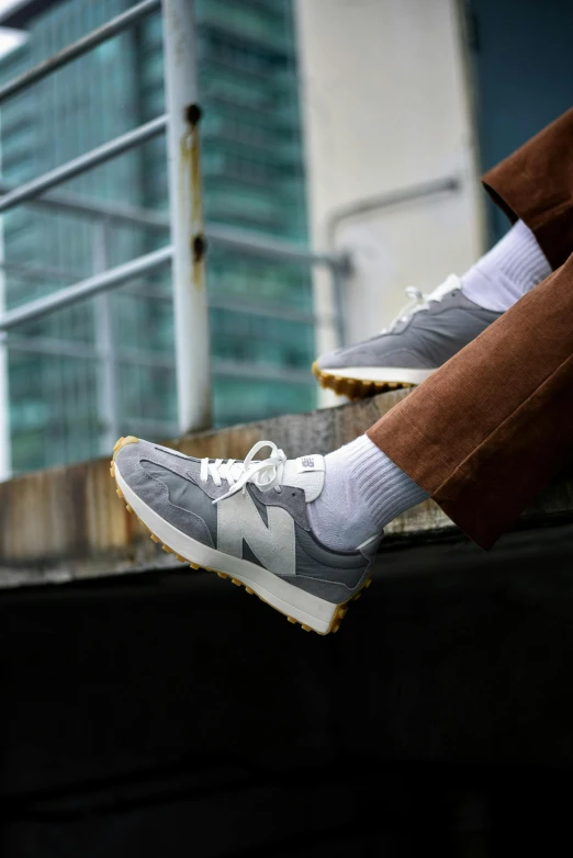 an upper view of a man's feet, wearing brown pants and a pair of running shoes