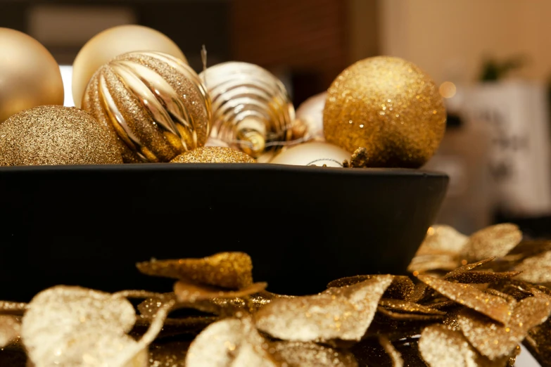 many shiny christmas decorations are in a bowl