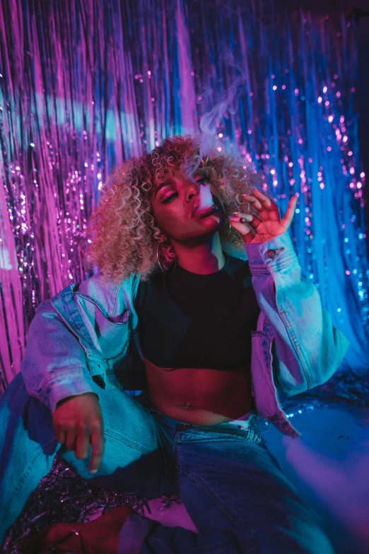 a woman sits on a bed next to a neon light