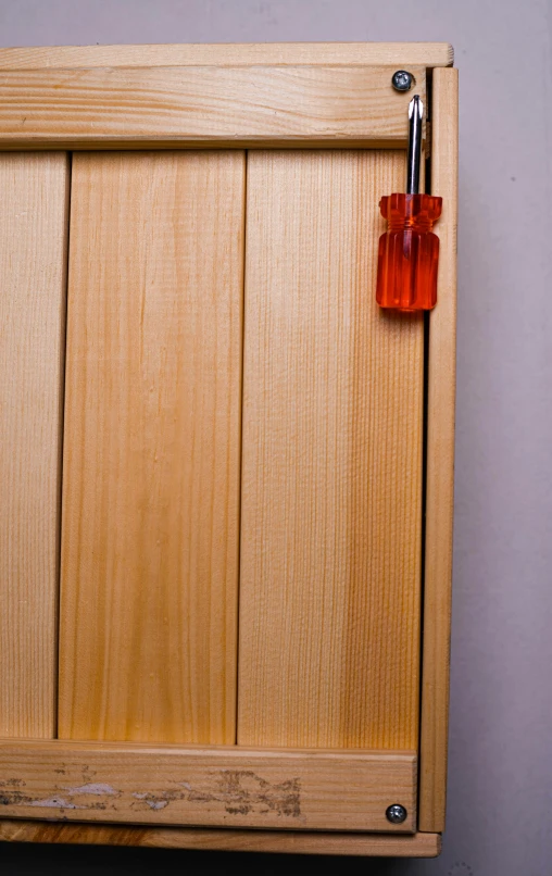 a wooden cabinet with a small red square cut off of it