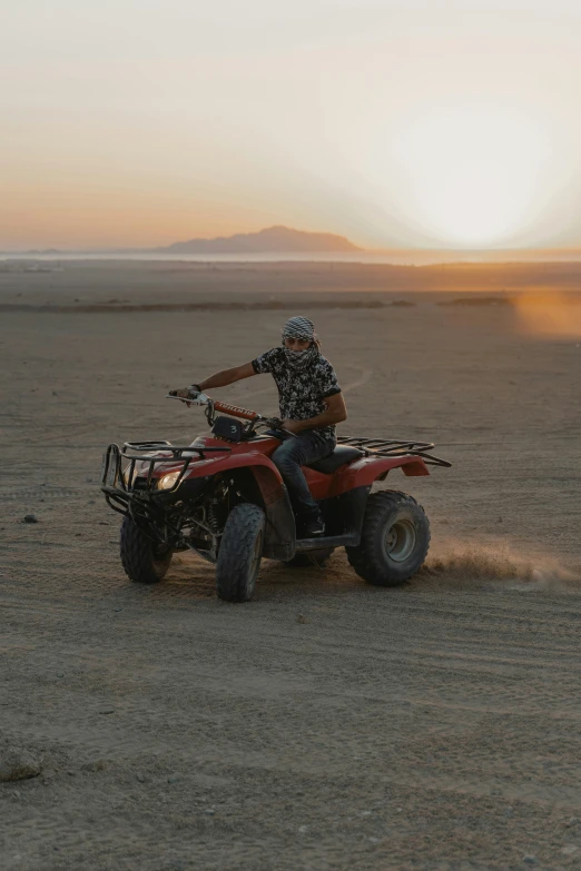 a man riding an atv through the desert