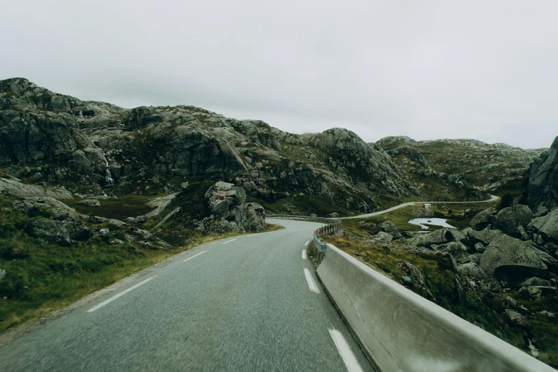 a highway in the mountains on a cloudy day