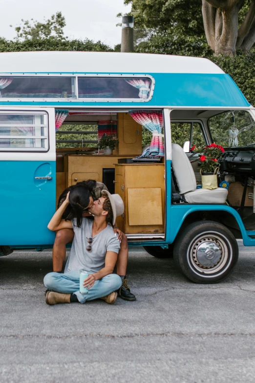 a man is hugging his girlfriend in front of a van