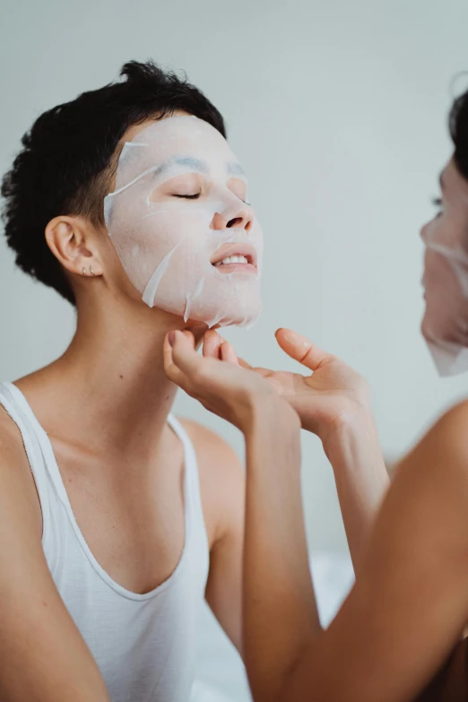 an asian woman puts on the mask from a young lady