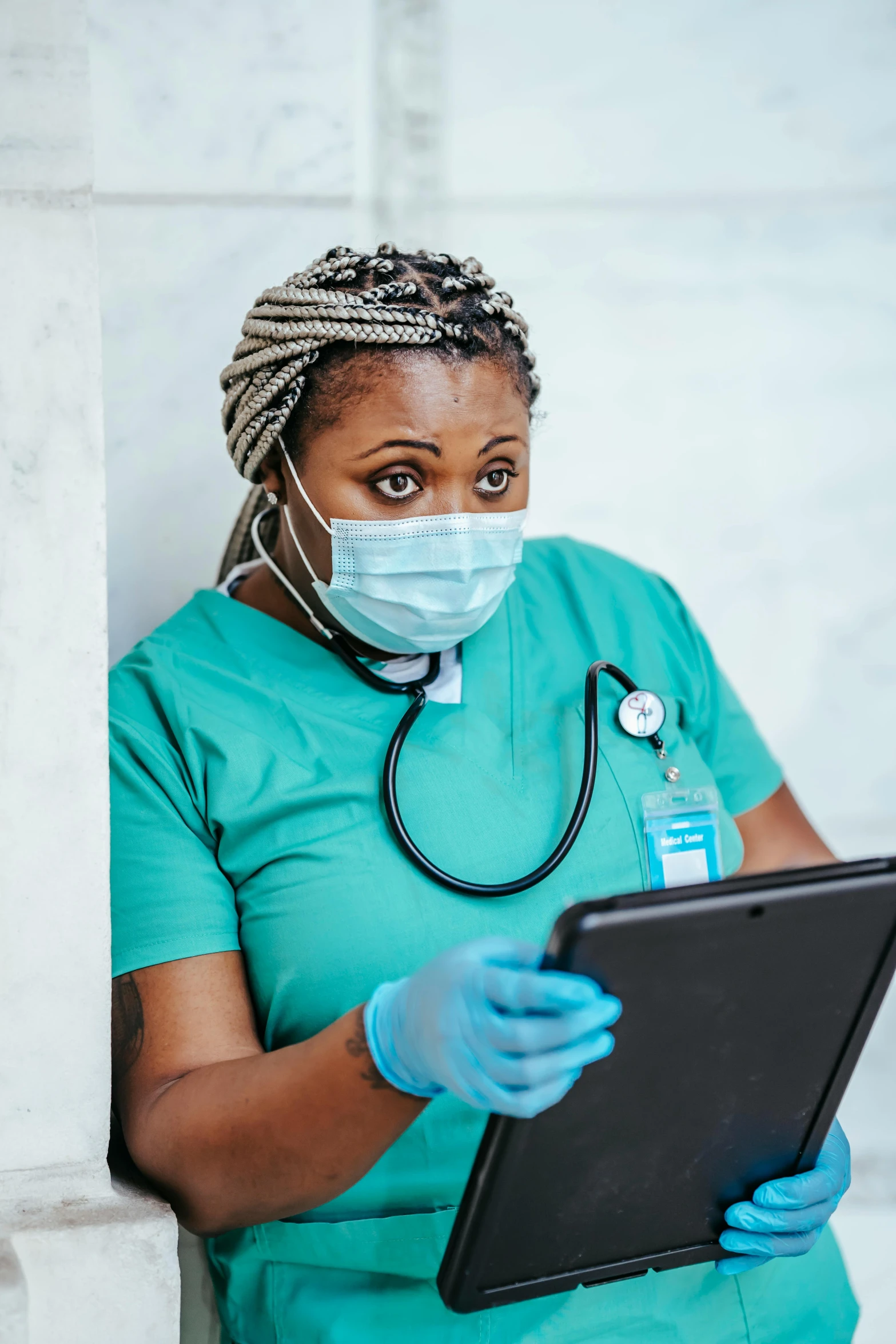 a woman with gloves on is holding a tablet