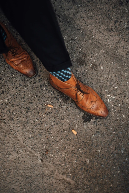 a brown derby shoe is on the ground