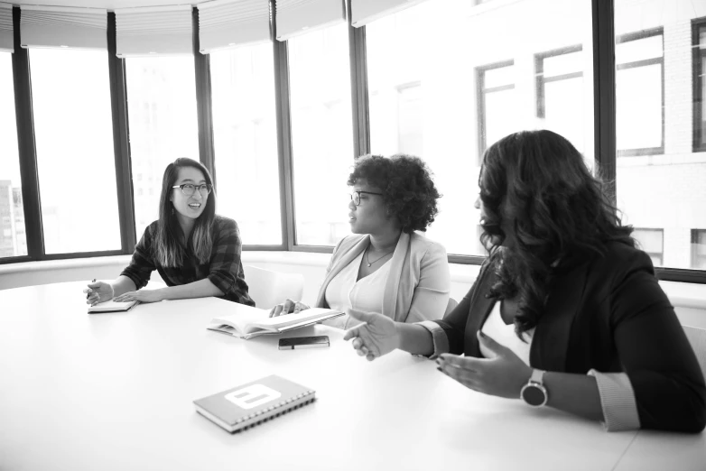 three women sitting at a table having a discussion