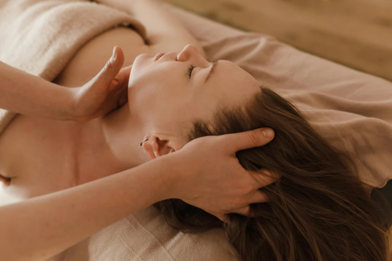 a woman with brown hair laying on a bed