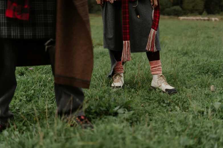 a man and woman standing in the grass