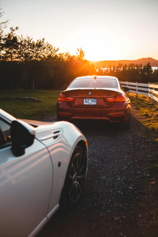 there is a car that is parked near a white fence