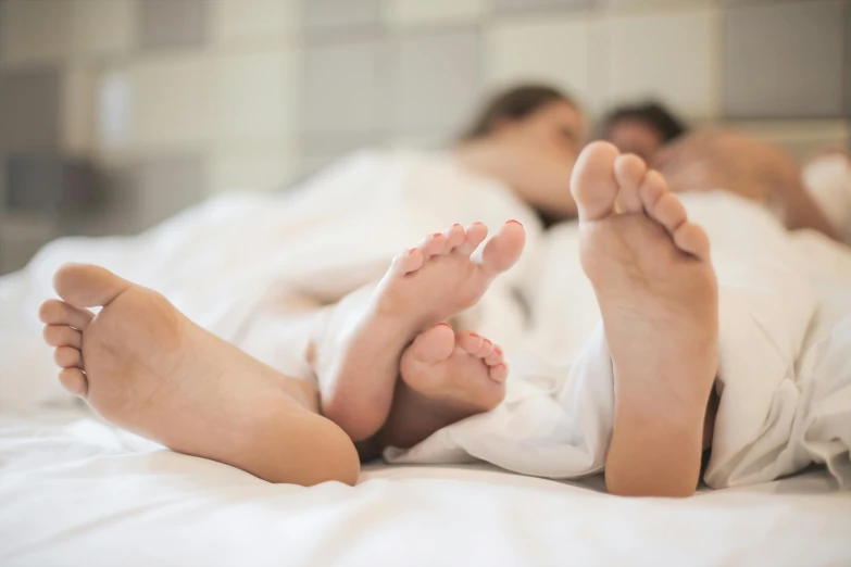 a couple relaxing in bed with their feet propped up