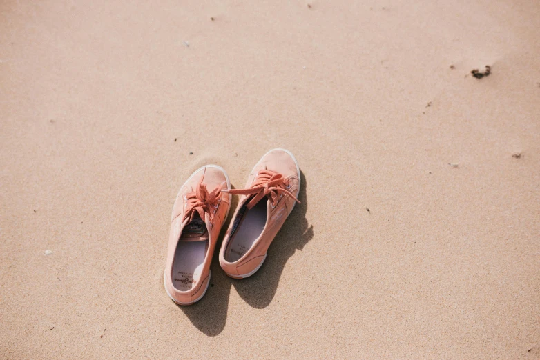 an aerial view of a pair of pink shoes on the beach