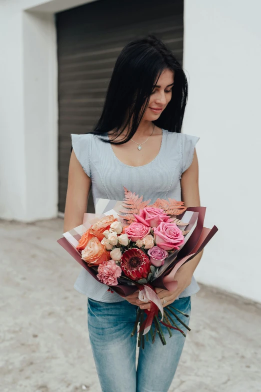 there is a young woman holding flowers near a garage door